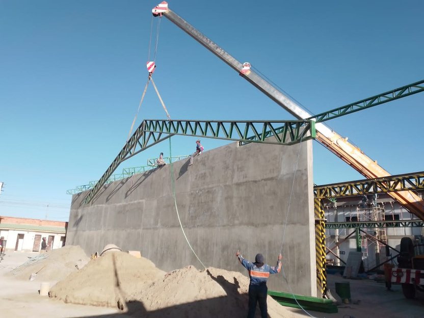 Montaje de cercha metálica con grúa en nave industrial